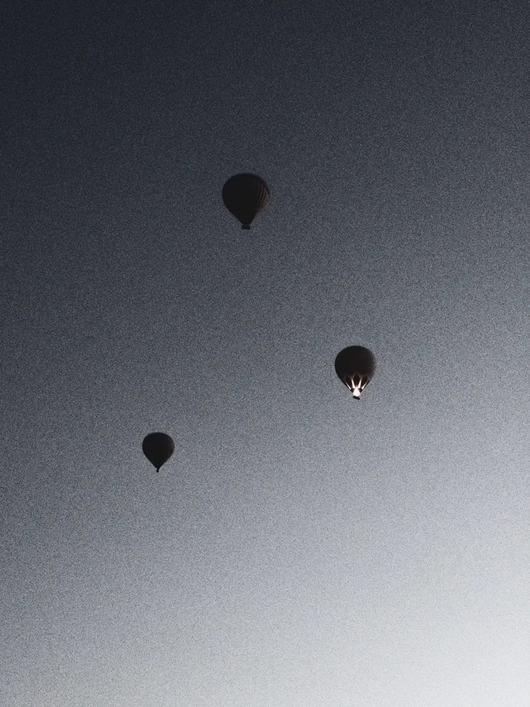 A black and white image of three balloons flying in Cappadoccia, Turkey