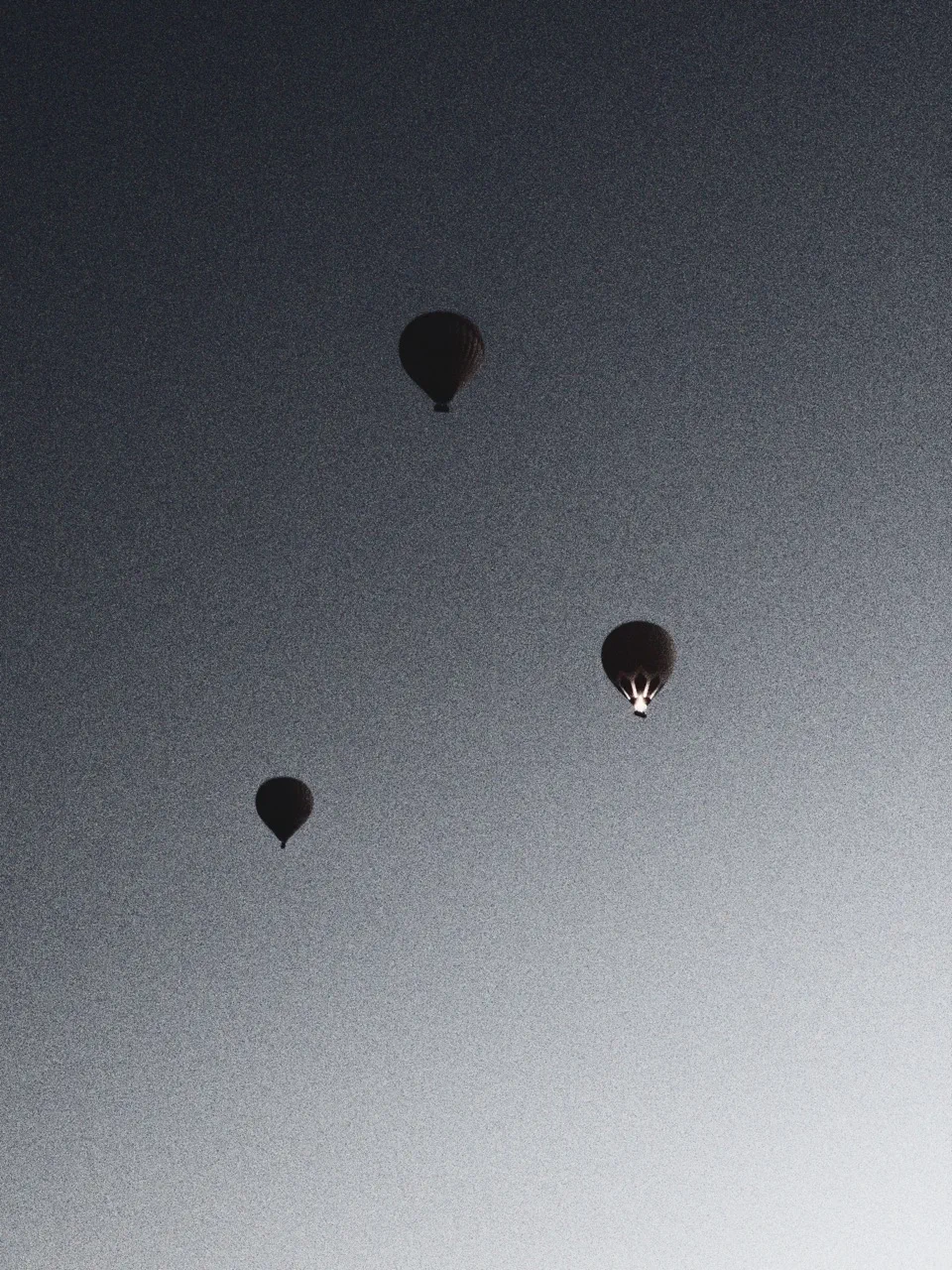 A black and white image of three balloons flying in Cappadoccia, Turkey